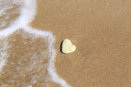 Stone in form of heart lies on sandの写真素材