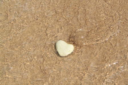 Stone in form of heart lies on sandの写真素材