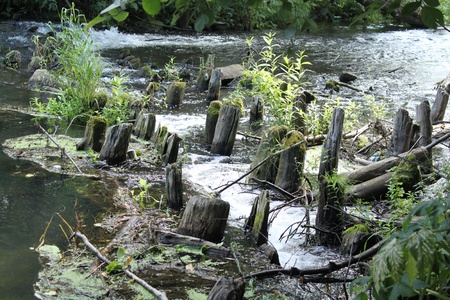 Ruins of the old bridge through small riverの写真素材