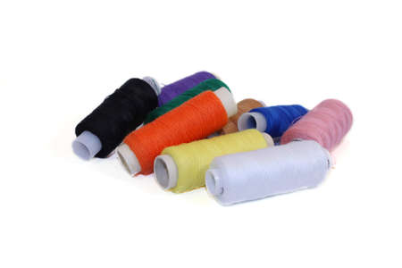 Pyramid of many-coloured bobbins of thread isolated on white