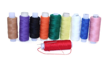 Spool of thread and needle on a white background