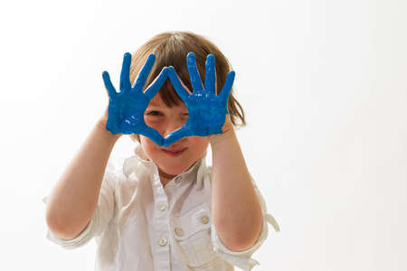 child with paint on the hands in front of a white backgroundの写真素材
