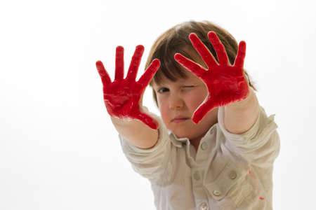 child with paint on the hands in front of a white backgroundの写真素材