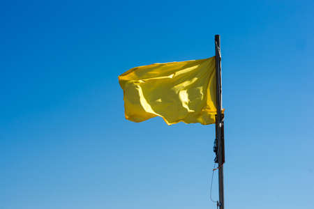 yellow flag as a warning sign on a beach