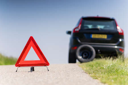 Car with problems and a red triangle to warn other road usersの写真素材