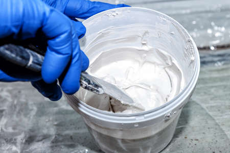 Manual mixing of white plaster with a spatula