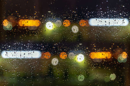 bokeh background with water drops on glass, colored objects pouring out