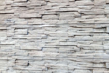 The background of the fence details is made of artificial stone siding with various textures