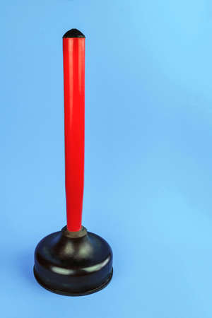 hand pump with red wooden handle for cleaning sedimentary blockages, on a blue backgroundの写真素材