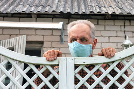 a lonely old man with a protective face mask during quarantine