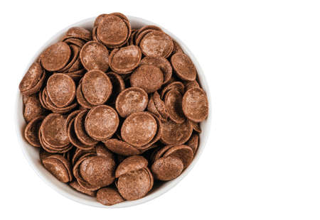 a bunch of chocolate shells in a bowl, isolated on a white background top view
