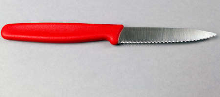 toothed kitchen knife on a gray background with space for a copyの写真素材