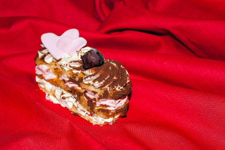 frozen ice cream dessert decorated with hearts and a berry on a red background