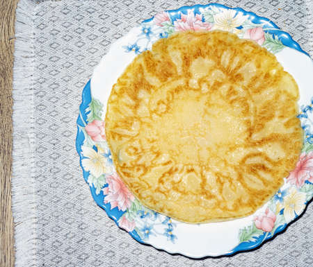 Baked pancake made of flour, egg and milk on a plate with a napkin, top viewの写真素材