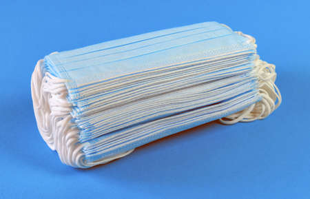 Three-layer medical face masks on a blue backgroundの写真素材