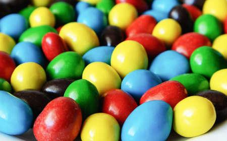 Colored peanuts in milk chocolate and sugar husk macro with blurred backgroundの写真素材