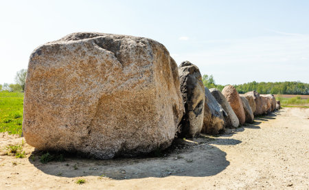 Lots of big stones standing in line, according to the road in Lithuania, on a sunny dayの写真素材