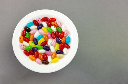 Candy jelly beans, sorted on a plate on a gray background view from aboveの写真素材