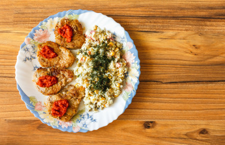 Pork fillet steaks on a plate with a mixture on a wooden table surfaceの写真素材