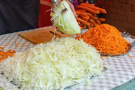 Shredded with a razor two piles of cabbage and carrot strips on pallets