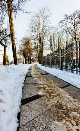 The city sidewalk was cleaned and sprinkled in the morning in winterの写真素材