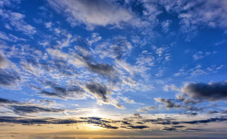 Autumn evening sunset sky landscape background with clouds and sunlightの写真素材
