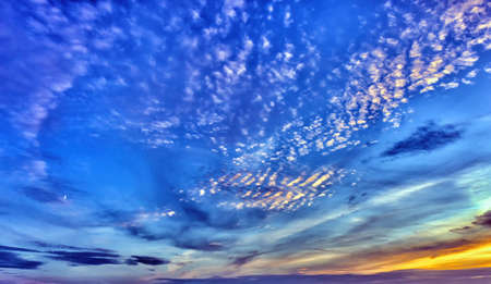 Landscape of the evening sky with small clouds and the delay of the moon in the distance