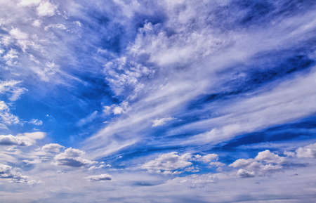A blue summer sky background with scattered white clouds
