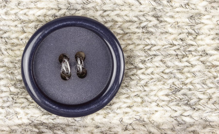 Dark round sewn button in knitted man-made fiber fabricsの写真素材
