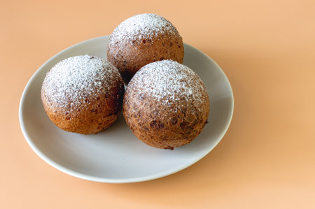 View from above of a plate of Lithuanian large donuts on a light brown background