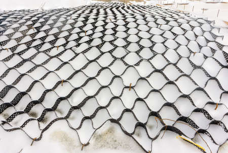 Geostrips are attached to the slope of the pond in winter. In the spring it will be filled with...