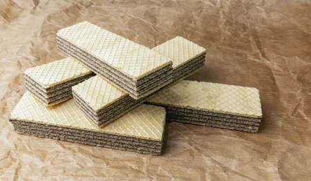 A pile of waffles with nut filling on a crumpled paper background, top view