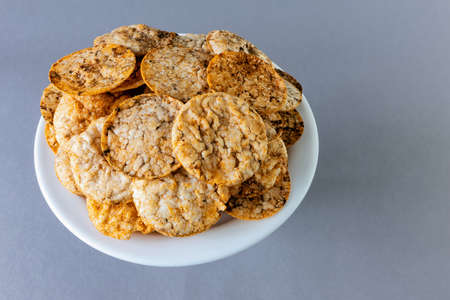 brown rice chips with spices on a plate on a gray background, top viewの写真素材