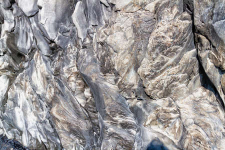 View of the rocky Reynisfjara rock texture on a black sand beach near Vico in southern Iceland