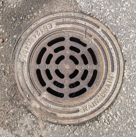 Round rain sewer cover - top view of the grid in the asphalt cover. Panevezys, Lithuania 16 d. in April 2022のeditorial素材
