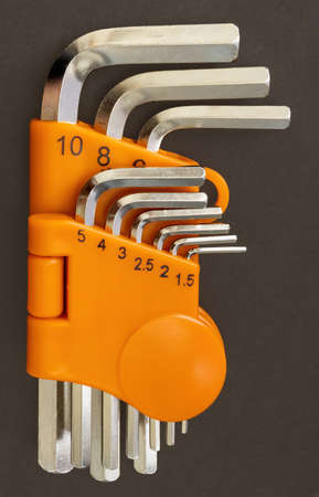 set of hexagonal steel screwdrivers in an orange box on a dark background