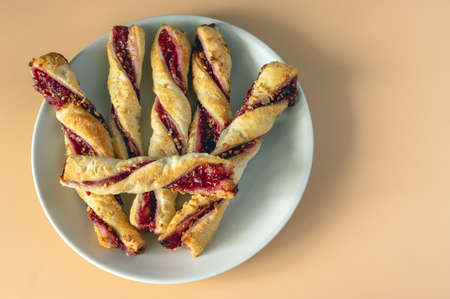 plate of sugar-free rolls with raspberry jam on an orange background, top viewの写真素材