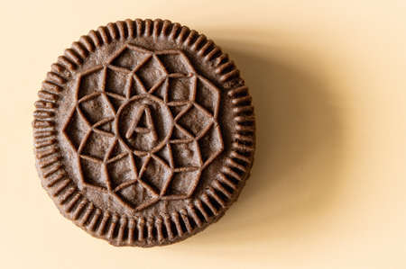 round cocoa biscuits with vanilla filling on an orange background, stacked up