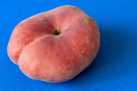 Fresh ripe donut flat peach on blue background, top viewの写真素材