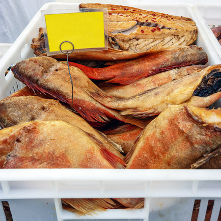 Large hot-smoked sea bass in a box are sold at the marketの写真素材