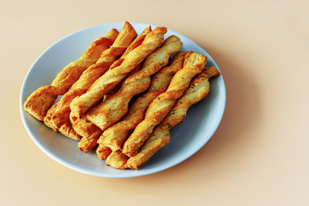 Rolled sticks of buttery yeast dough on a plate on an orange background