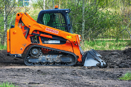 Cramo mini loader with rubber tracks, a bulldozer leveling the ground in the park. Panevezys....
