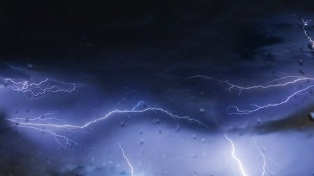 You can see the lightning during the rain at night through the fogged window glassの写真素材