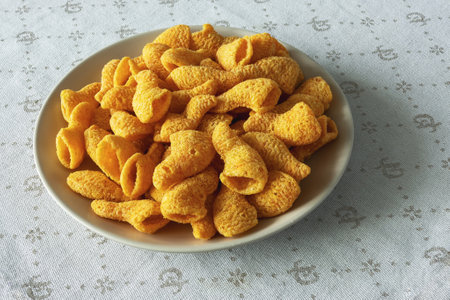 Yellow cone shaped snack crackers on plate on table napkin close up