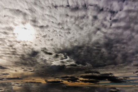 During the day, the sun tries to break through the dark clouds in the sky