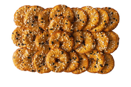 Pile of salted round crackers with black and white sesame isolated on white background.