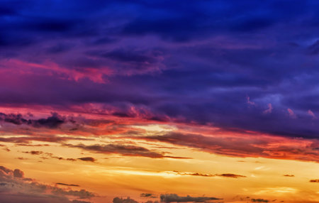 The sunset sky boasts a mesmerizing mix of purples, oranges and blues. The vivid cloudscape creates an attractive and dynamic backdrop for any visual project.の写真素材