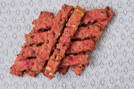 Freshly baked cookies made with seeds and vegetables are placed on a soft linen napkin, highlighting...