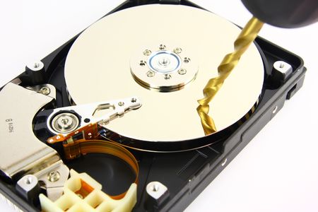 Opened Hard drive lying on the white background with drill, close up