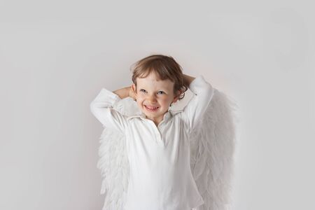 Beautiful little angel boy, white clothes, wings, blue eyesの写真素材